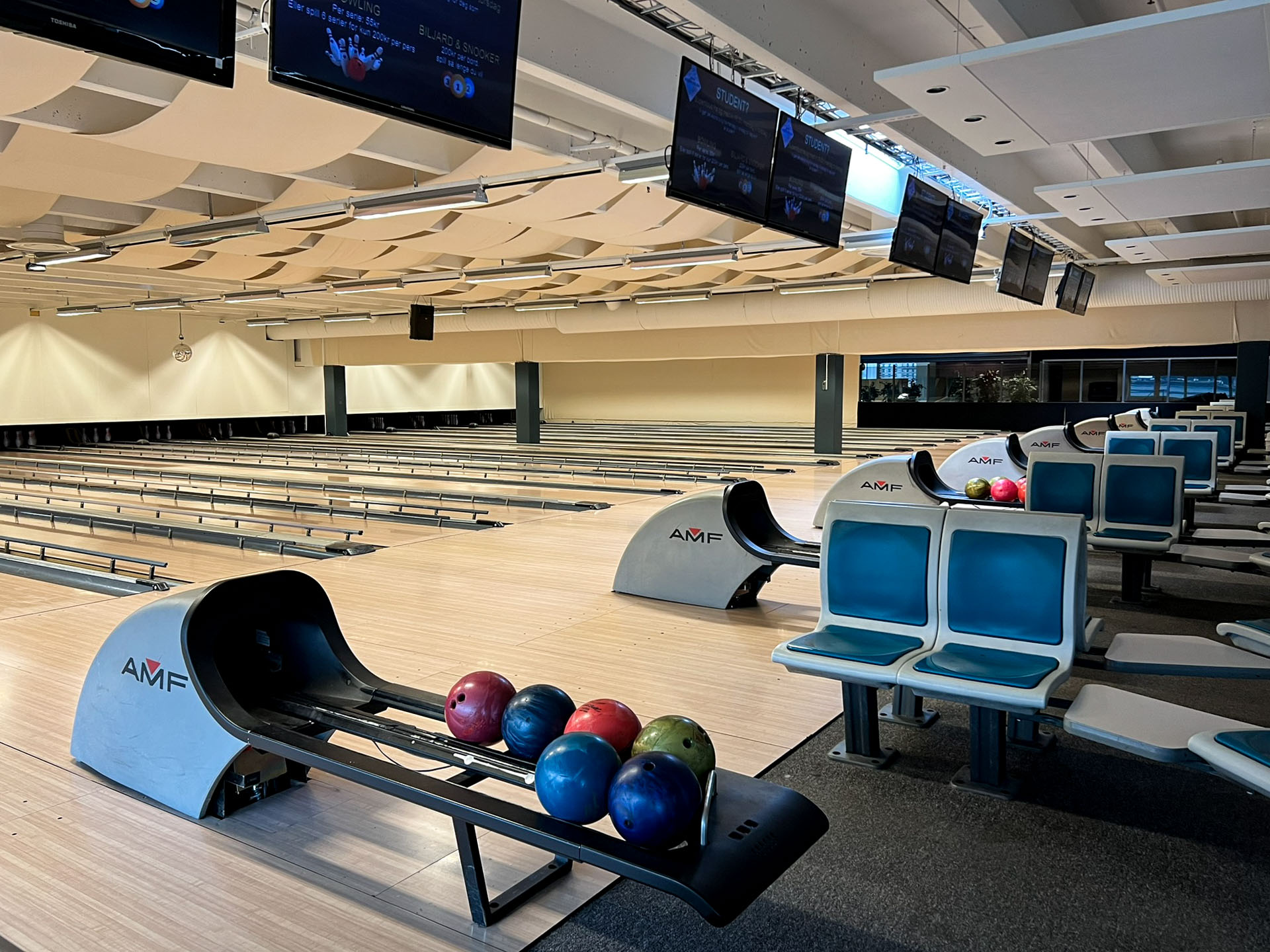 Bowlinghallen sett fra siden — 16 baner og flerfargede baller på ballreturen